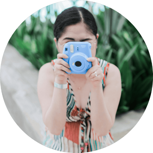 a girl takes dressed with a colorful summer dress takes an instax picture